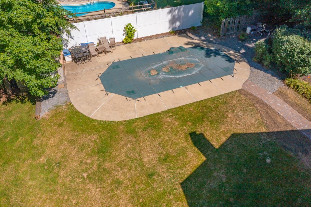 Aerial view of a backyard pool under a winter cover