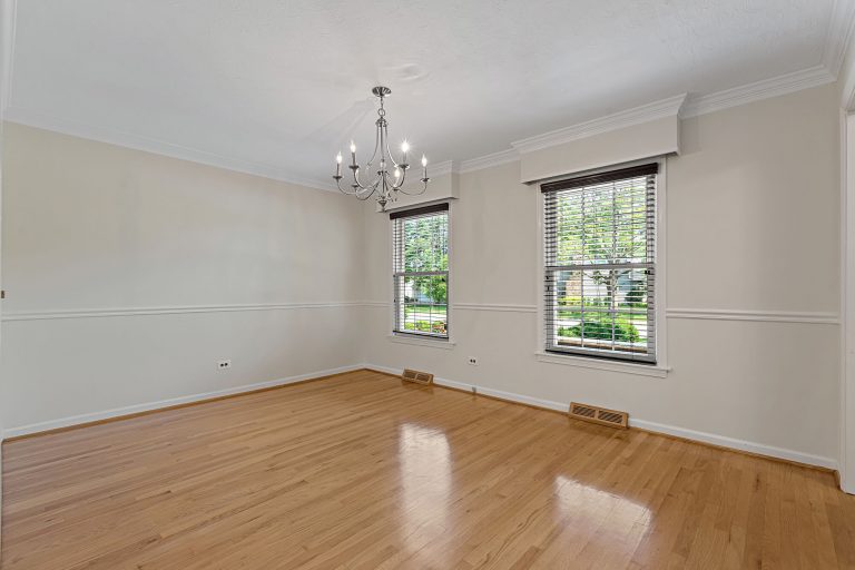 Empty dining room with wood floors and two windows