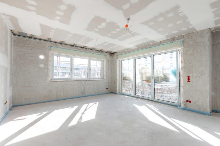 Unfinished room with bare concrete walls and an unpainted ceiling
