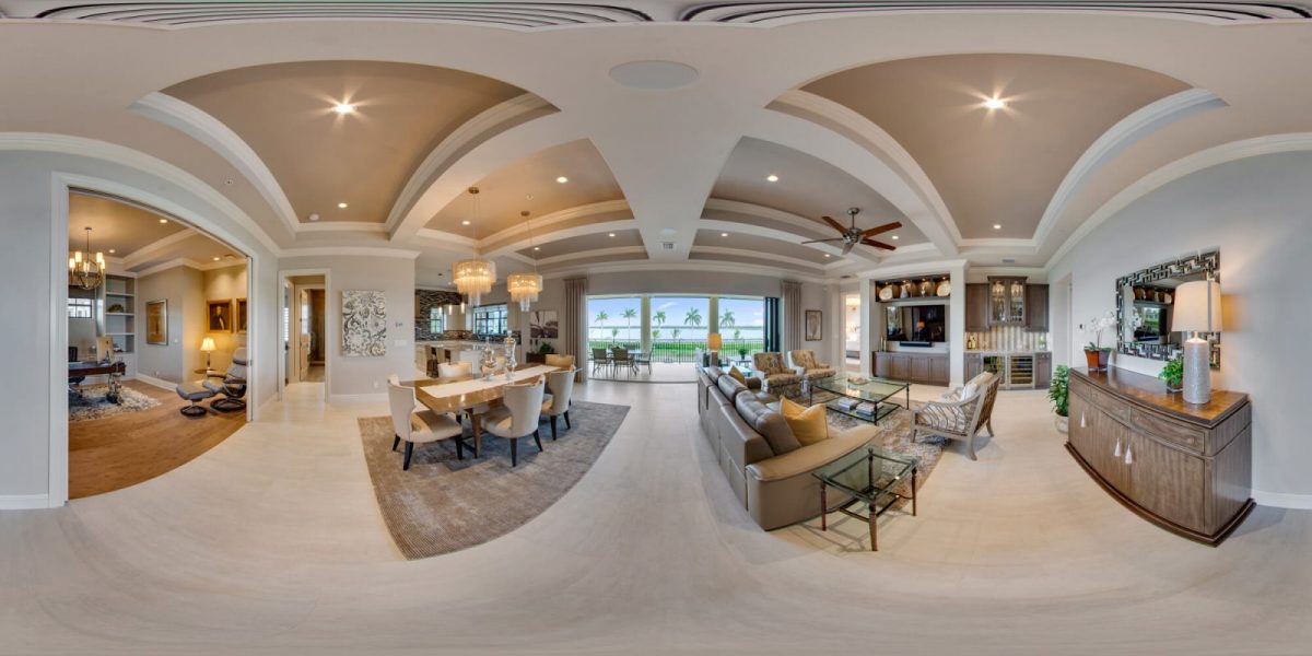 Stitched 360° equirectangular panorama of an open-plan living and dining room with a coffered ceiling and a view to the lanai