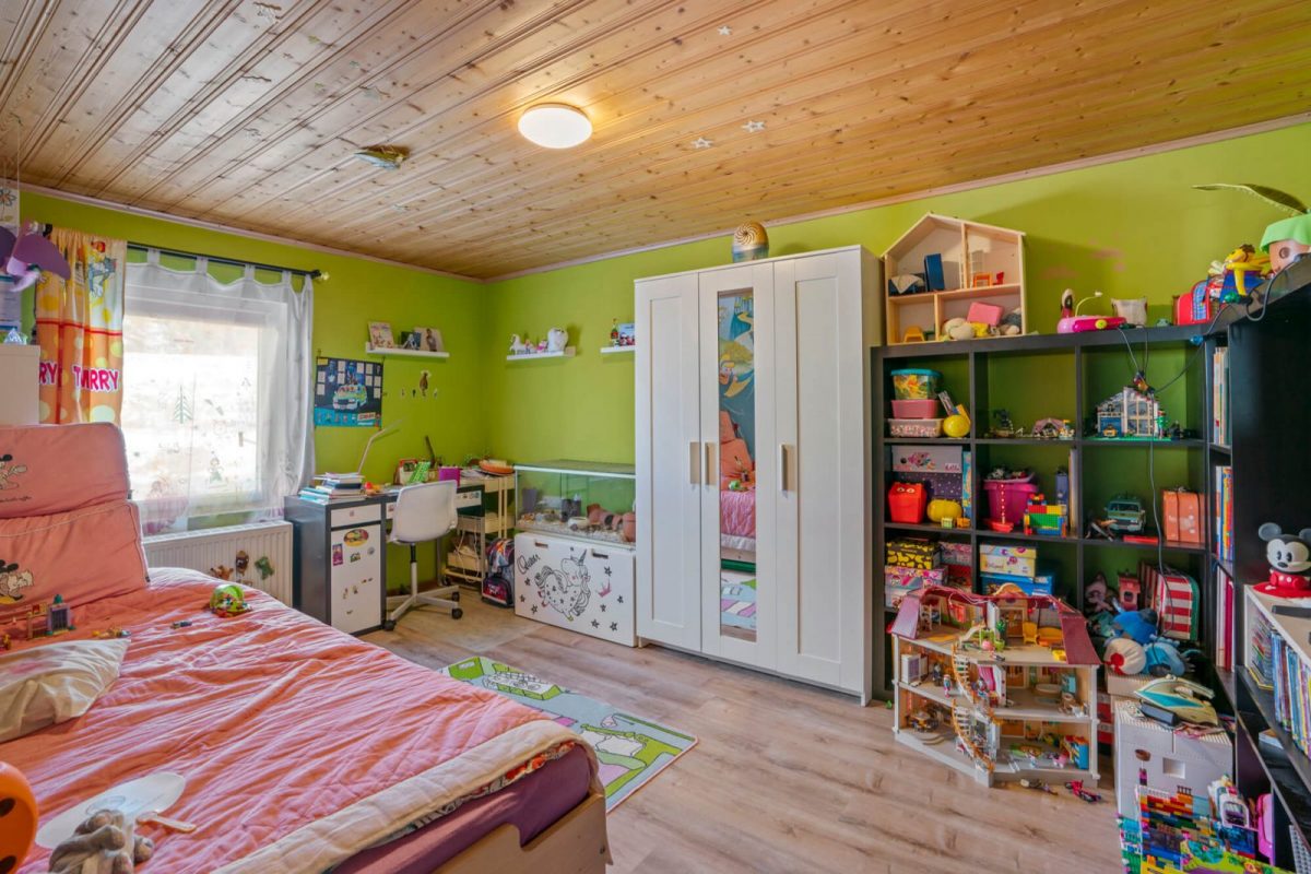 Child's bedroom filled with toys, shelves and furniture, before item removal