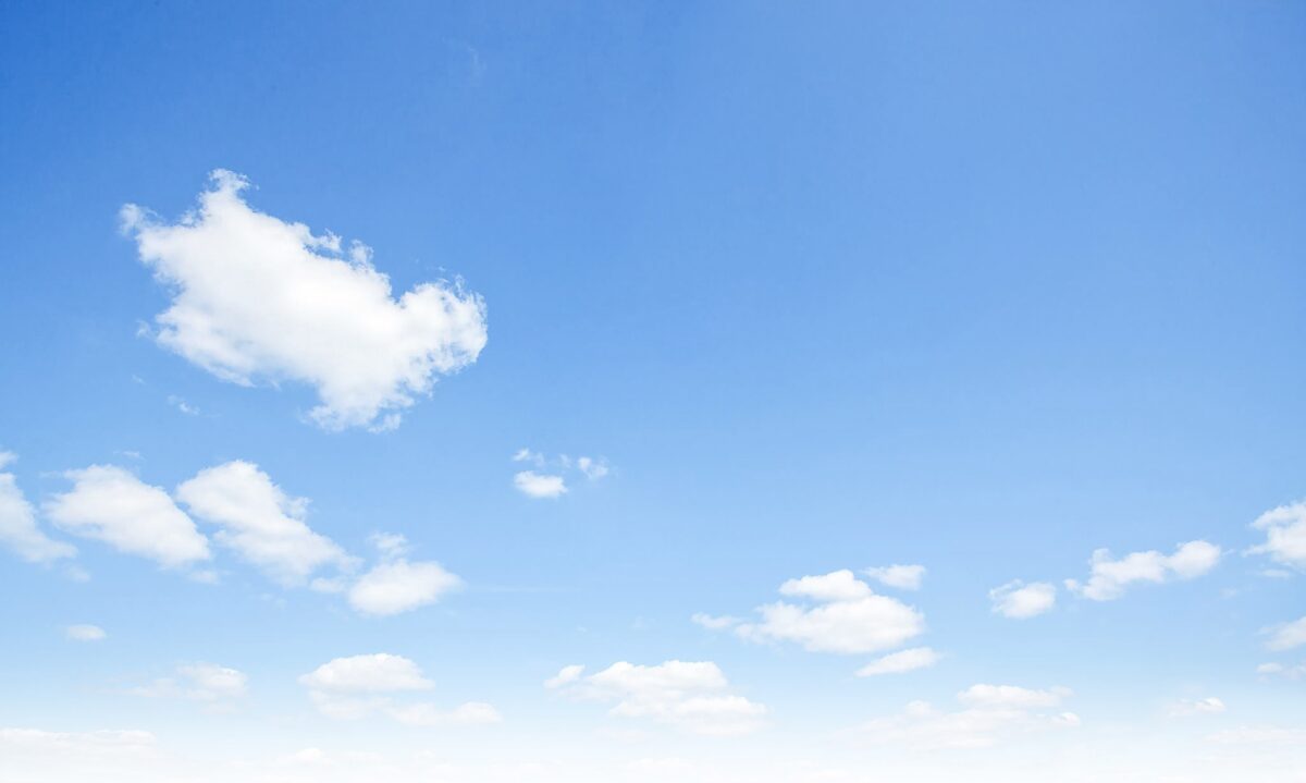 Clear blue sky with small white clouds