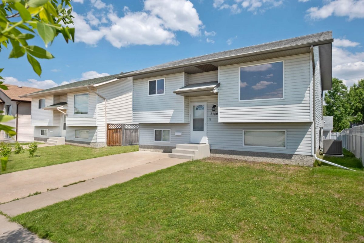 Split-level house with a clear driveway and lawn after item removal